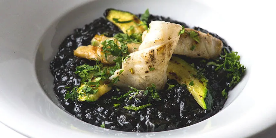 Squid ink risotto with grilled fish