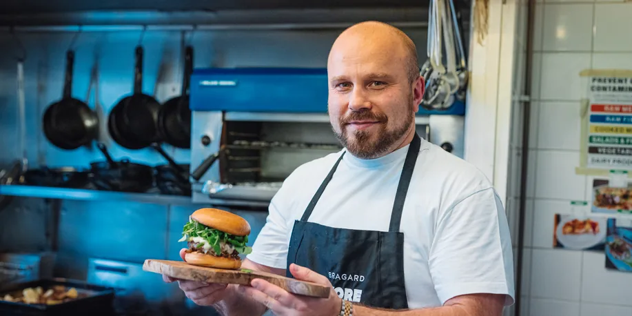 Our chef in the kitchen with a freshly made burger