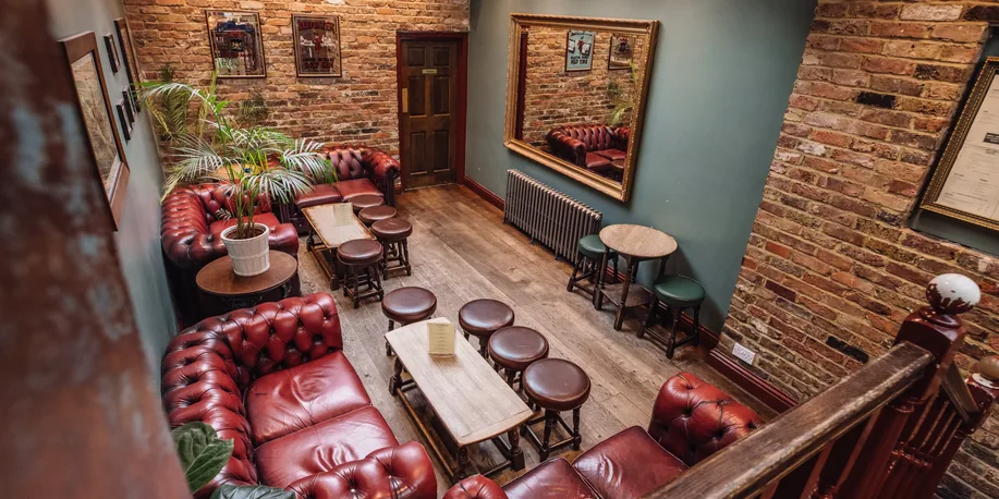 The downstairs room at The Warwick with chesterfield sofas, set for an exclusive event